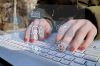 © LeoOrigami - stock.adobe.com Foto: Hände auf Tastatur mit Icons